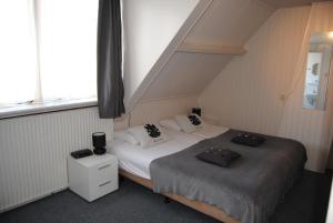 een kamer met 2 bedden en een raam bij Het Verschil in Zoutelande