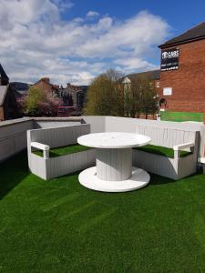 una mesa blanca y bancos en un campo de hierba en Rooftop Apartments, en Belfast