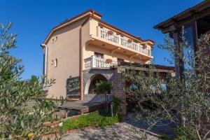 ein großes Haus mit Balkon darüber in der Unterkunft B&B Tonivale in Skrbčići