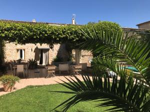 ein Haus mit einer Terrasse mit einer Palme in der Unterkunft Le relais d'Angélique in Lunel