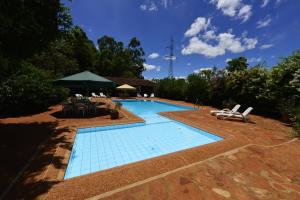 una piscina con due lettini e un ombrellone di Hotel Restaurant Papillon a Bella Vista