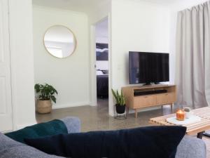a living room with a couch and a tv at FortyOne - Oceanside Retreat Busselton in Busselton