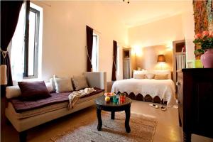 ein Schlafzimmer mit einem Bett, einem Sofa und einem Tisch in der Unterkunft Riad Davia in Marrakesch