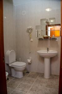 y baño con aseo y lavamanos. en Solar dos Marcos Rural Accommodation en Bemposta