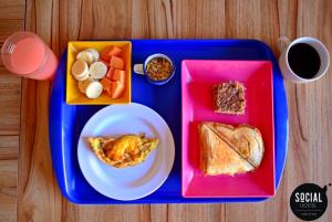 a lunch tray with a plate of food and a sandwich at Social Hostel Café e Bar in Curitiba