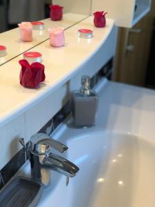 La salle de bains est pourvue d'un lavabo avec des bougies rouges sur un comptoir. dans l'établissement Apartment Satori, à Korenica