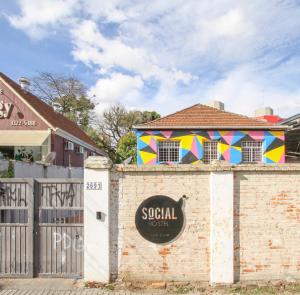 a sign on the side of a brick building at Social Hostel Café e Bar in Curitiba