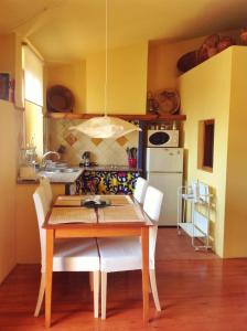 Apartamento La Costa في بيريلادا: مطبخ مع طاولة خشبية وكراسي بيضاء