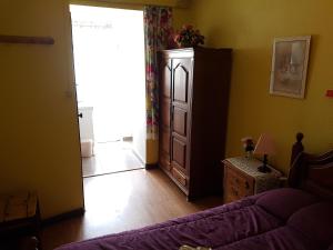 a bedroom with a bed and a dresser and a door at Residencial Bem Estar in Vila Real