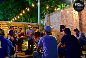 a group of people sitting around a band at a concert at Social Hostel Café e Bar in Curitiba