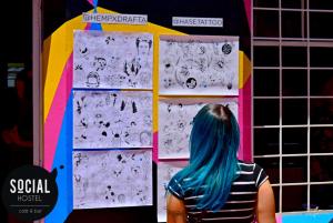 a woman with blue hair standing in front of a wall at Social Hostel Café e Bar in Curitiba
