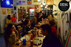 a group of people sitting at tables in a restaurant at Social Hostel Café e Bar in Curitiba