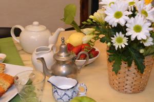 uma mesa com uma chaleira e um vaso de flores em Casa Mama em Nápoles