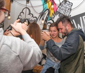 a man helping a woman get her hair dried at Social Hostel Café e Bar in Curitiba