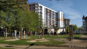 un parque infantil en un parque frente a un edificio en Horyzont 806 en Międzyzdroje