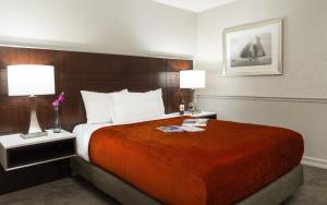 a hotel room with a bed and a lamp at ALO Hotel by Ayres in Anaheim