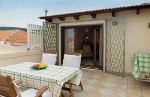 a patio with a table and chairs on a balcony at Elois Suites in Rethymno Town