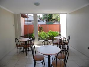 DianópolisにあるMosaico Hotelのテーブルと椅子、大きな窓が備わる客室です。