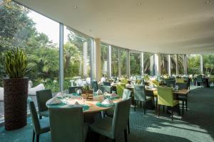 a restaurant with tables and chairs and windows at HF Ipanema Park in Porto