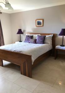 um quarto com uma cama grande e almofadas roxas em Park View em Glenties