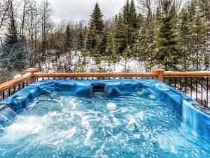 a hot tub on a deck in the snow at Le Mont-Tremblant - Résidences Boutique in Lac-Superieur