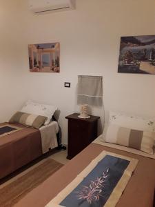 1 dormitorio con 2 camas, mesa y espejo en Giardini di Lanzo, en Martina Franca