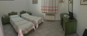 um quarto com duas camas e uma televisão em Sant Efisio em Lotzorai