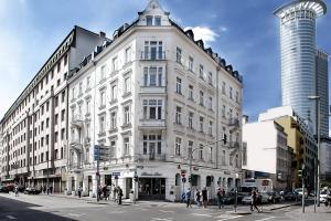 un gran edificio blanco en una calle de la ciudad con gente en Grand Hotel Downtown, en Frankfurt