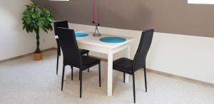 イェレニャ・グラにあるKamienicaの白いテーブル(椅子2脚、青い皿付)
