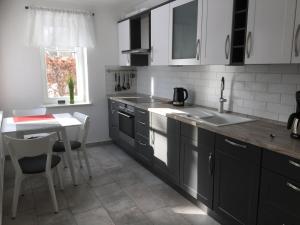 una cocina con armarios en blanco y negro y una mesa en Wolffs-Idyll en Prerow