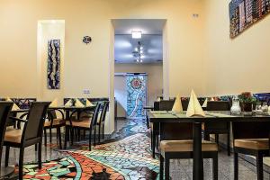 Un restaurante con mesas y sillas en una sala. en Grand Hotel Downtown, en Frankfurt