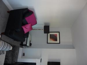 a room with a shelf with a tv and a picture at Hewlett Apartments in Cheltenham