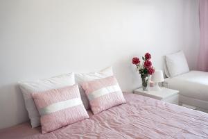 um quarto com uma cama com almofadas cor-de-rosa e brancas em Graca Views Apartment em Lisboa