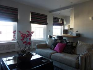 a living room with a couch and some windows at Hewlett Apartments in Cheltenham
