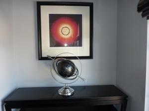 a desk with a globe on a table with a picture at Hewlett Apartments in Cheltenham