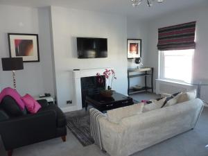 a living room with two couches and a fireplace at Hewlett Apartments in Cheltenham
