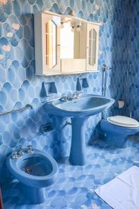カステッルッツォにあるLa Grande Palmaの青いバスルーム(洗面台、トイレ付)
