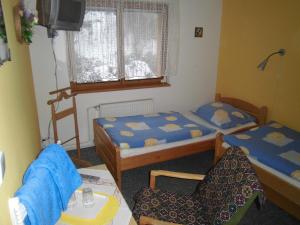 ブルノにあるKupková ubytování v soukromíのベッド2台と椅子が備わる小さな客室です。