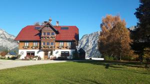 a house with a red roof on a green lawn at Kulmerhof - Farm in Pruggern