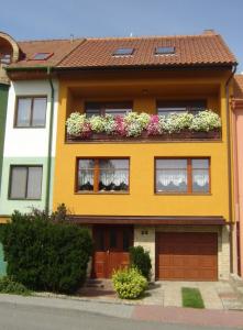 a yellow house with flowers in a window box at Kupková ubytování v soukromí in Brno