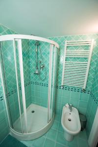 La salle de bains est pourvue de carrelage bleu, d'une douche et de toilettes. dans l'établissement AmoRoma al Pantheon, à Rome