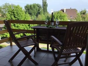 two chairs and a table with wine glasses on a balcony at Soós Apartman in Balatonfüred +9 photos
