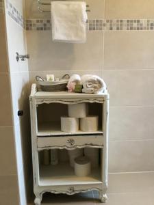 a white shelf in a bathroom with a cat sleeping on it at Soós Apartman in Balatonfüred