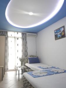 a bedroom with two beds and a blue ceiling at Apartments Aza in Dobra Voda