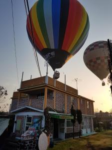 dos globos de aire caliente volando sobre un edificio en Hotel Fer, en San Juan Teotihuacán