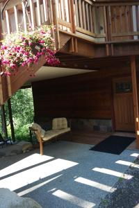 Eagle Peak Guesthouse في Eagle River: شرفة منزل مع مقاعد و ورود