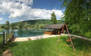 un cenador junto a un lago con un columpio en Villa Giulia, en Bihać