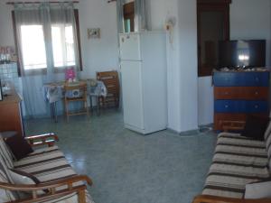 a kitchen with a refrigerator and a table and chairs at Dafni's Home 50 meters from the beach in Yerakiní