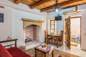 a living room with a brick fireplace and a table at Petronikoli Traditional House in Choudetsi