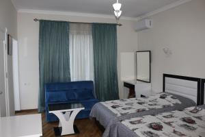 una camera d'albergo con due letti e una sedia blu di Guest House Sofia a Kobuleti